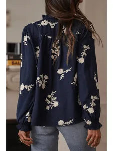 Detailed back view of a navy blue blouse with intricate white floral embroidery.