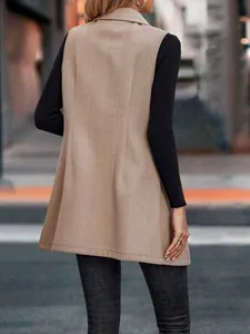 Vista posteriore di un elegante gilet lungo a spina di pesce beige da donna in città