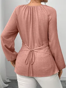 Vue arrière de l'élégant chemisier rose poudré à manches longues avec lien à la taille