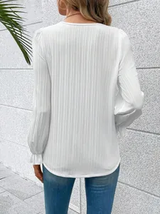 Back view of a white long-sleeve blouse with vertical texture and ruffled cuffs