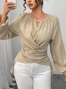 Vue détaillée du chemisier beige à manches longues avec taille nouée et décolleté perlé