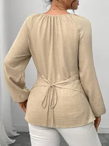 Vue arrière d'un chemisier kaki à manches longues pour femmes avec nœud à la taille.