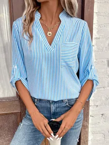 Gros plan sur l'élégante blouse rayée bleue et blanche avec col en V et poches
