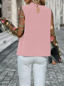 Rückansicht einer rosa Stehkragenbluse mit floral bestickten Netzärmeln im Detail