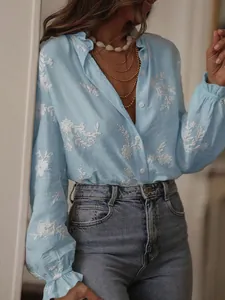 Close-up of a light blue embroidered blouse featuring puff sleeves and floral detail