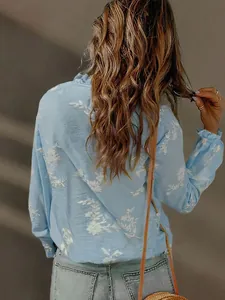 Back view of women's light blue casual shirt with delicate white floral embroidery details
