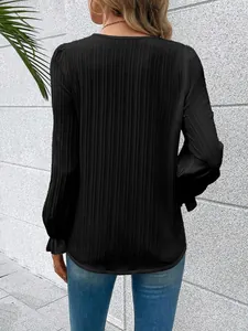 Back view of black long-sleeved blouse with ribbed texture and ruffled cuffs