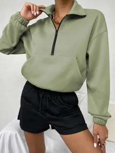 Detailansicht eines salbeigrünen Half-Zip-Sweatshirts mit Oversized-Passform und Kängurutasche.