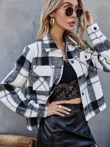 Detail view of a stylish black and white plaid wool jacket with lapel and button accents