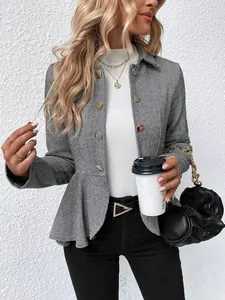 Detalle de cerca de una chaqueta peplum de espiga en blanco y negro con botones dorados