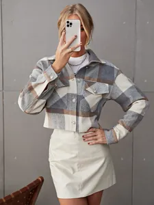 Detailopname van een stijlvol geruit wollen kort jasje met revers en knoopdetails.