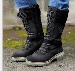Detailed side view of black mid-calf lace-up combat boots with knitted collar.