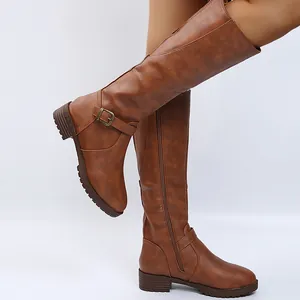 Detailed side view of brown knee-high leather boots with side zipper and buckle detail