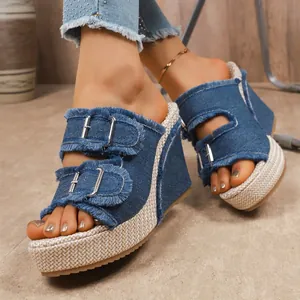 Close-up detail of stylish denim wedge sandals with frayed edges and silver buckles