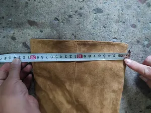 Detailed view showing tape measurement of a brown suede over-the-knee boot shaft width