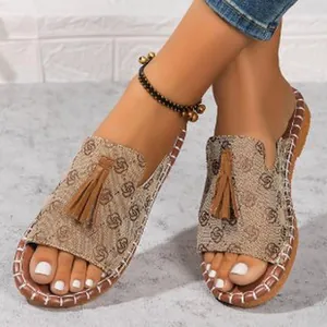 Macro detail view of women's flat sandals featuring a stylish tassel and open-toe design