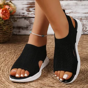 Close-up view of stylish women's black mesh wedge sandals with comfortable platform soles