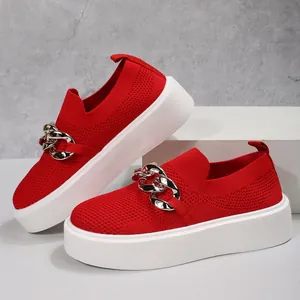 Detailed view of red flyknit slip-on sneakers with gold chain and platform sole