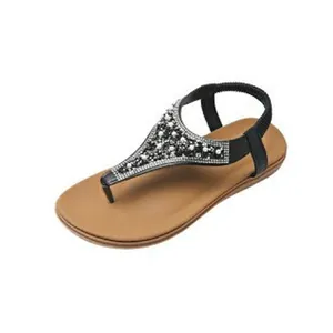 Detailed view of a bohemian black T-strap flat sandal with rhinestone and bead accents