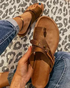 Vista detallada de sandalias retro de cuero marrón con diseño de dedo y hebilla rústica