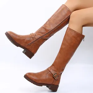 Close-up side view of brown knee-high knight boots with buckle straps and zipper