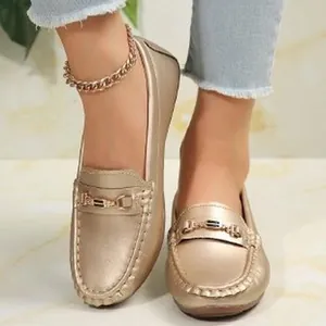 Elegant golden loafers featuring a metallic buckle and round toe design for women