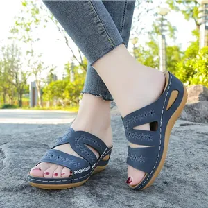 Détail de sandales compensées bleues pour femmes avec broderie florale en extérieur