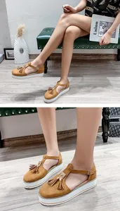 Detailed view of women's camel tassel platform sandals featuring a white thick sole.