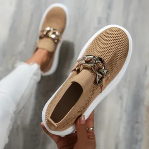 Detailed view of women's tan fly-knit slip-on shoes featuring a chunky silver chain