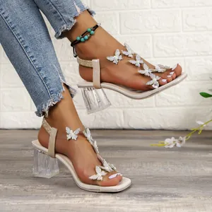 Detail shot of square toe sandals featuring sparkling butterfly charms and crystal heels
