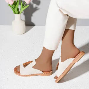 Fashionable women's casual flat slide sandals with canvas upper and brown tassel detail