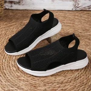 Detail view of stylish black mesh peep-toe sandals with white platform wedge soles