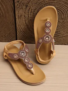 Detailed view of bohemian tan flat sandals with intricate beadwork and faux gem accents