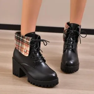 Detailansicht schwarzer Stiefeletten mit Blockabsatz und modischem Karomuster-Kragen.