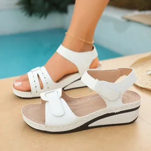 Sandali vintage bianchi con zeppa per donna con suola spessa e cinturini in velcro.