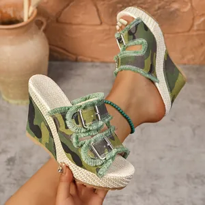 Close-up detail of camouflage denim wedge sandals with metal buckles and frayed edges