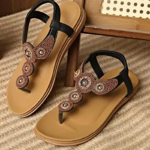 Detailed view of bohemian flat sandals with intricate bead flower embellishments.