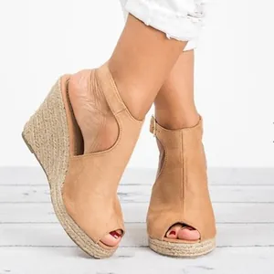 Close-up view of suede wedge sandals with peep toe design and braided jute platform