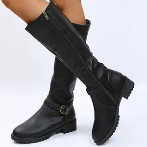 Detail of black leather knee-high knight boots with side zipper and buckle strap