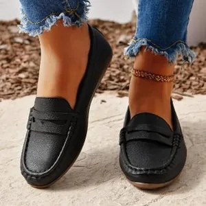 Close-up view of stylish black slip-on loafers for women with a textured finish and round toe