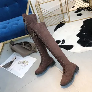 Detailed view of brown lace-up over-the-knee flat boots for women with suede texture