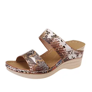 Detail of women's wedge sandals featuring snakeskin pattern and thick platform sole.