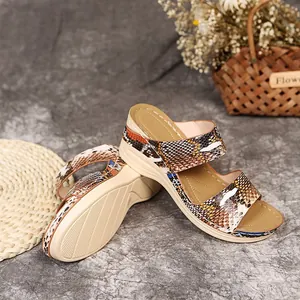 Detail view of women's snakeskin print wedge sandals with platform sole for summer beach