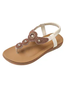 Detailed macro view of Bohemian flat sandals featuring intricate bead flower design