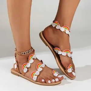 Detailed view of bohemian flat sandals featuring colorful rainbow and cloud embroidery