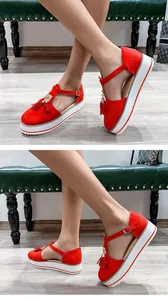 Detailed view of red suede platform sandals with decorative tassels and ankle straps.