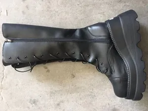 Detailed side profile of black platform knee-high lace-up knight boots with chunky soles