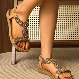 Close-up of Bohemian flat Roman sandals with circular beaded decorations on a model