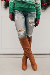 Close-up of stylish women's brown suede over-the-knee boots with chunky block heels