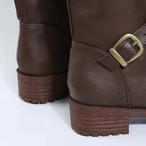 Close-up of brown tall knight boots with buckle detail and low heel.